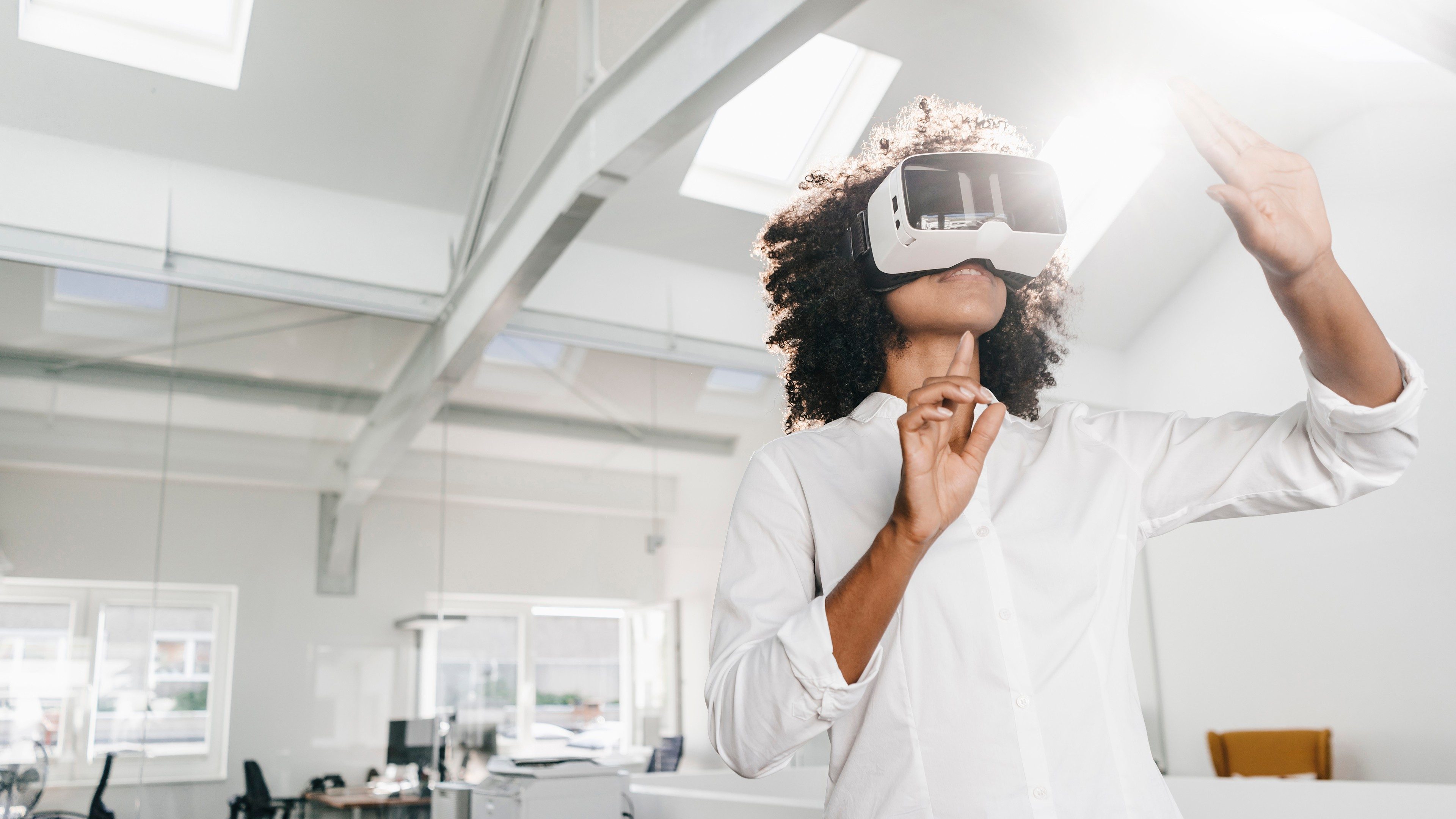 Une femme utilisant un casque de réalité virtuelle dans un bureau moderne, représentant l'anticipation des technologies de demain.