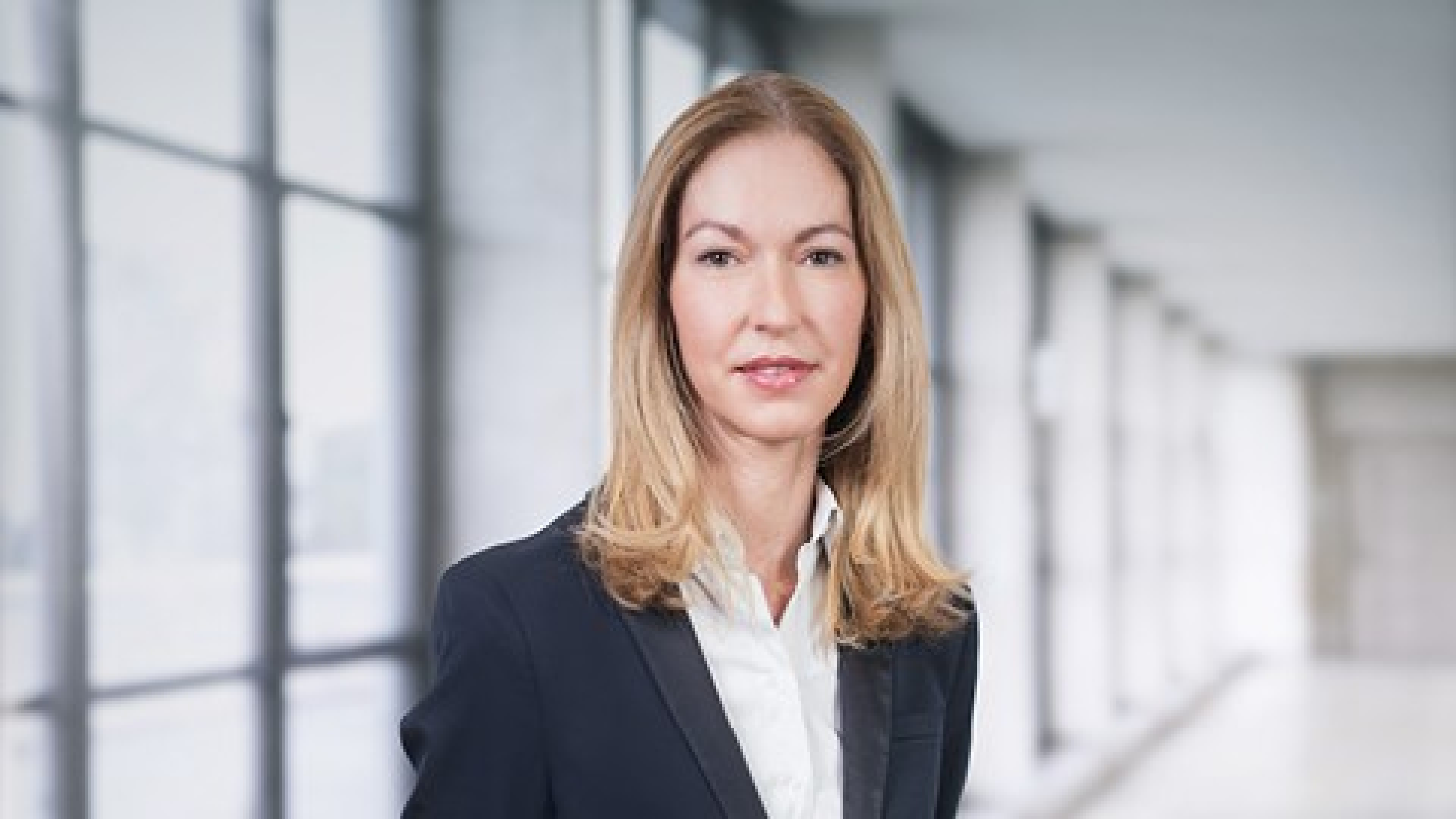 Portrait d'Aurélie Fouilleron, Directrice commerciale et marketing chez Swiss Life Asset Managers France, posant avec assurance dans un cadre professionnel moderne.