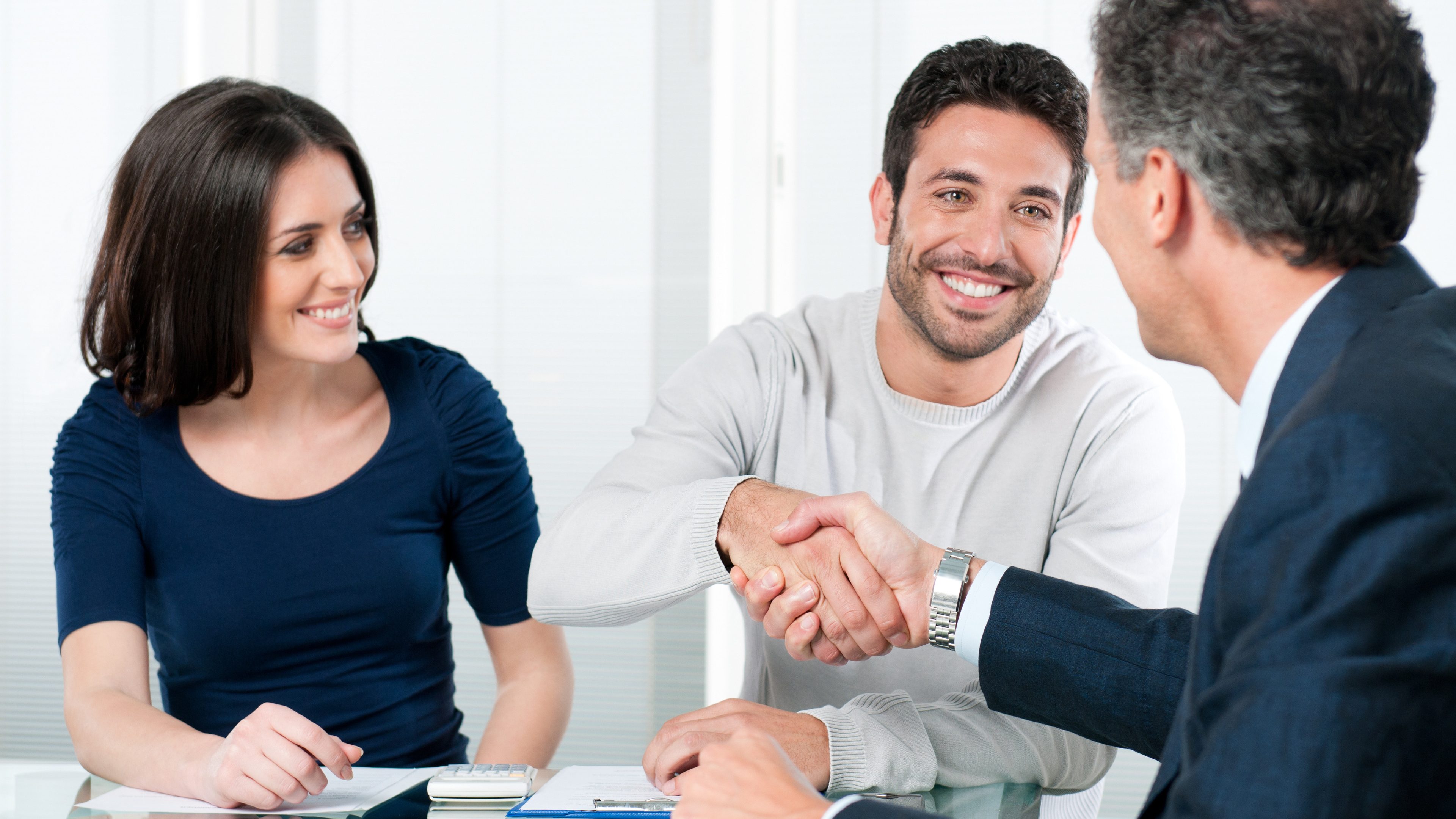 Happy couple seal a deal with their personal financial advisor at home