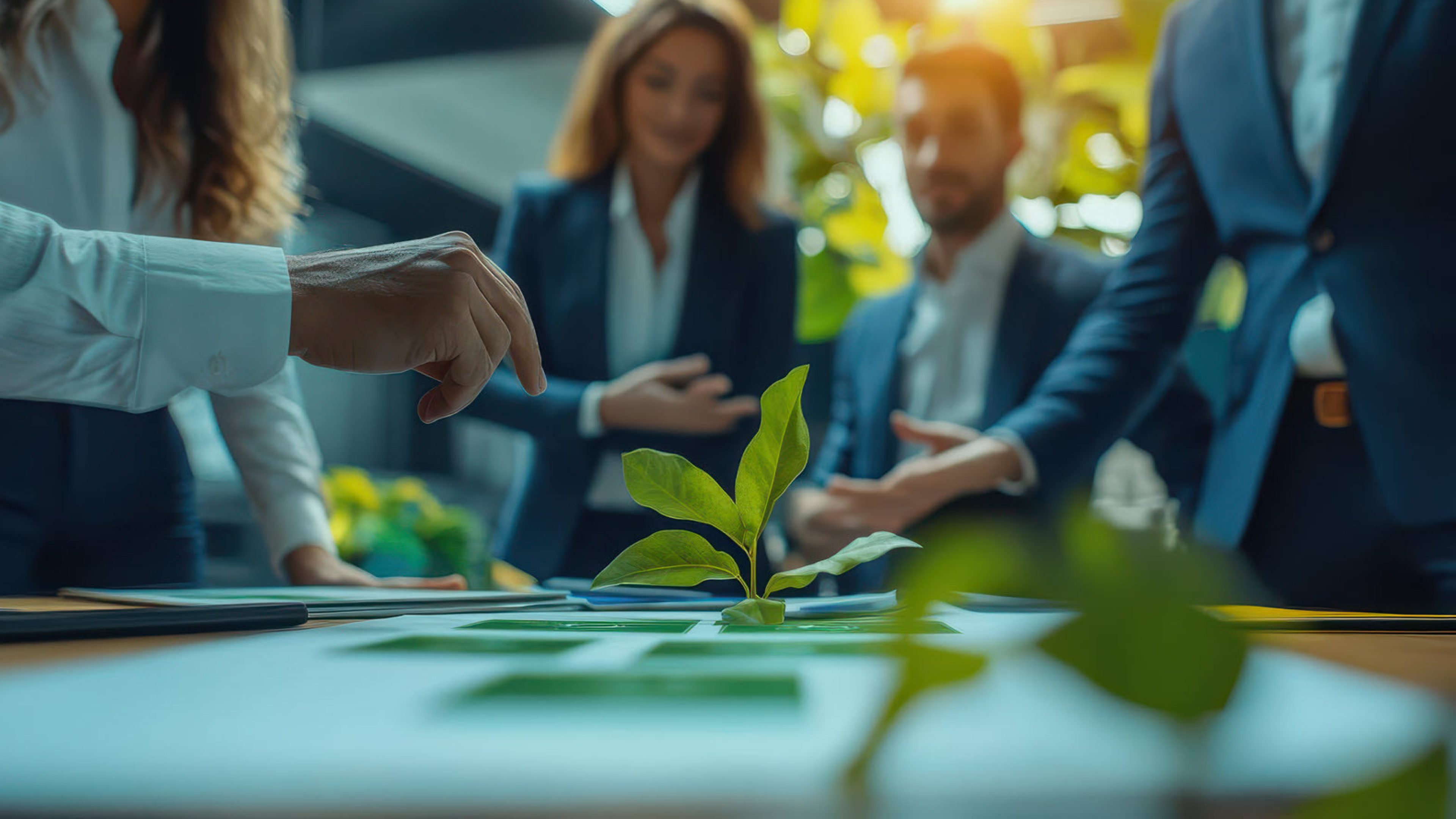 Des personnes qui se tiennent à une table sur laquelle on peut voir une plante.